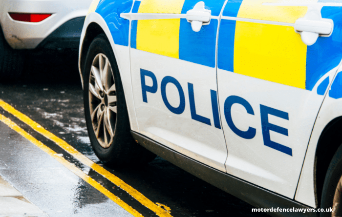 Police car pulled up behind a car on yellow lines