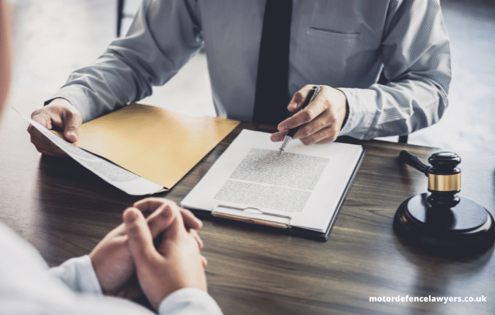 solicitor sitting opposite a man reading a file 